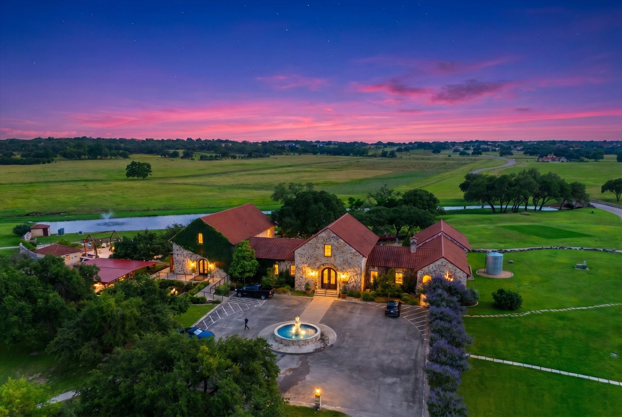 638 Strada Luca Florence, TX 76527 - Photo 36 of 38 Stone architecture under a vibrant twilight sky highlights this estate with a grand entry and fountain.