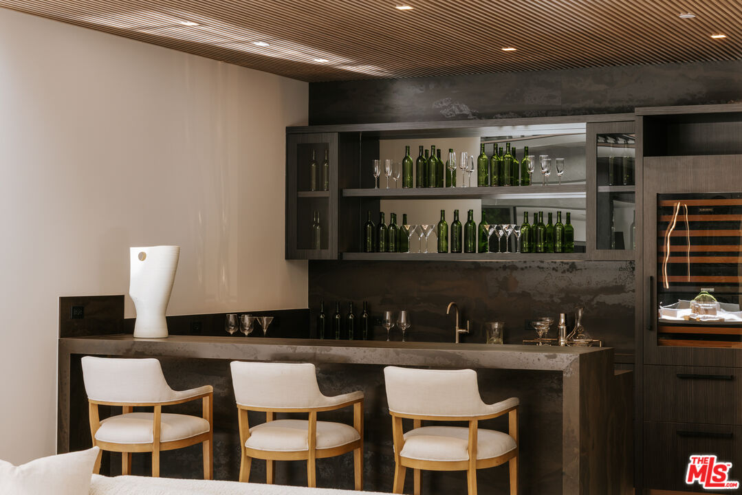 219 Homewood Road Los Angeles, CA 90049 - Photo 10 of 40 a kitchen with a dining table chairs and a counter top space