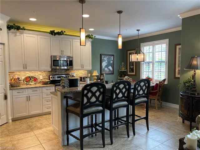 a kitchen with granite countertop white cabinets and stainless steel appliances