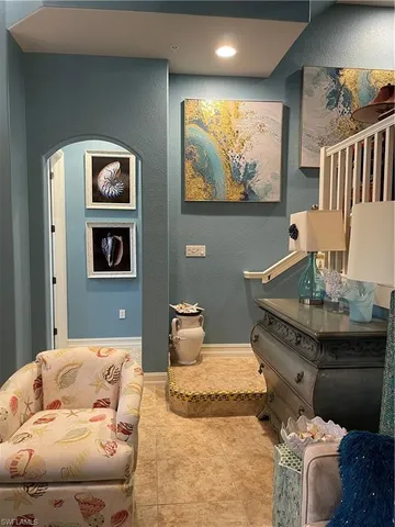 a bathroom with a toilet and a painting on the wall