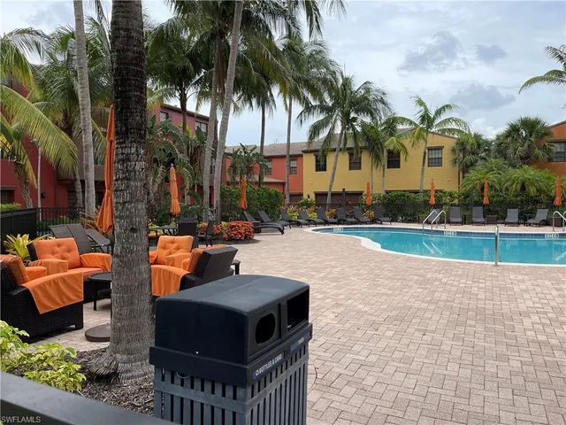 a row of palm trees and swimming pool in the backyard of a house