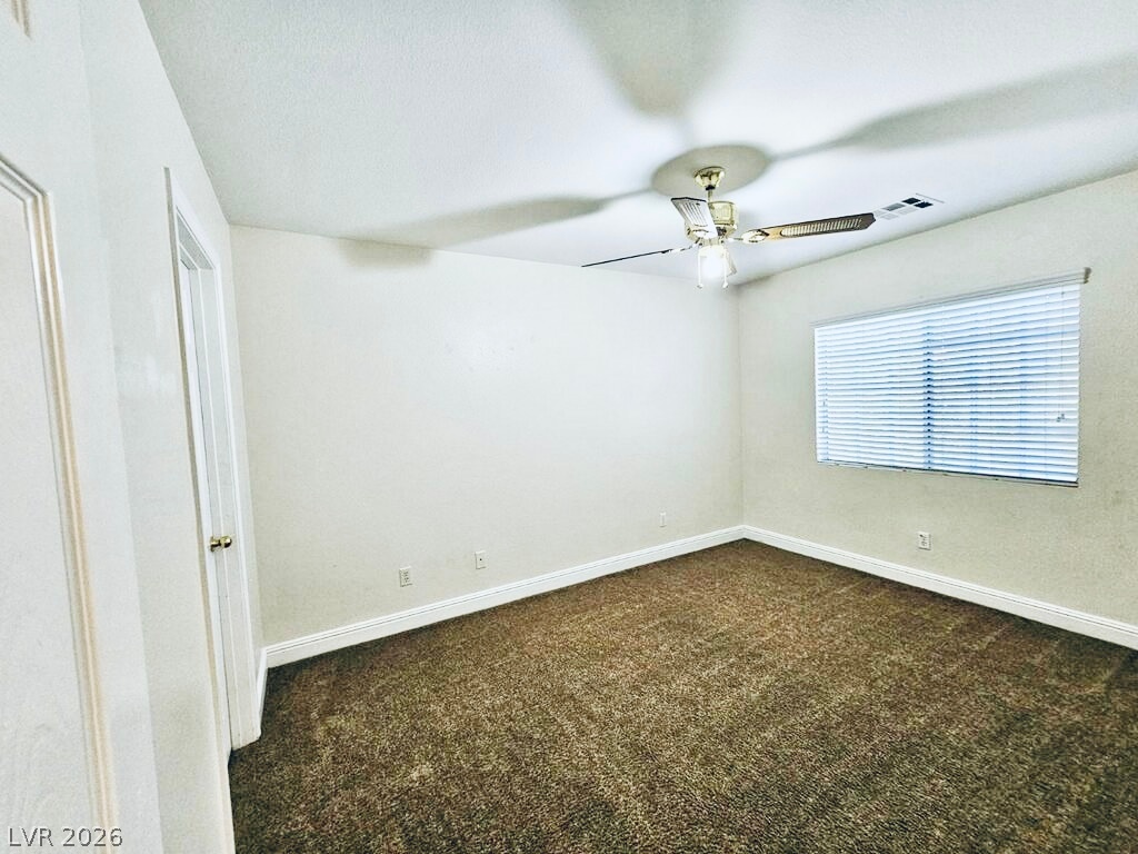 5953 Crumbling Ridge Street Henderson, NV 89011 - Photo 28 of 42 A well-lit bedroom features plush carpeting and a large window for ample natural light.