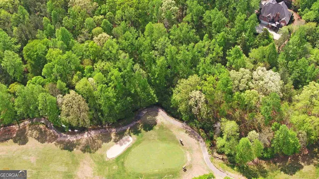 an aerial view of residential house with outdoor space and trees all around