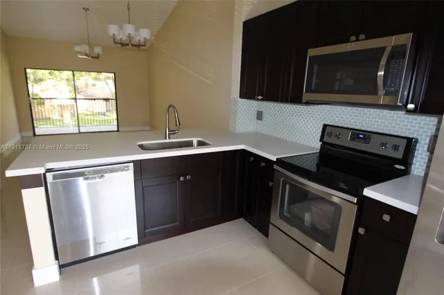 a kitchen with stainless steel appliances a stove microwave and sink