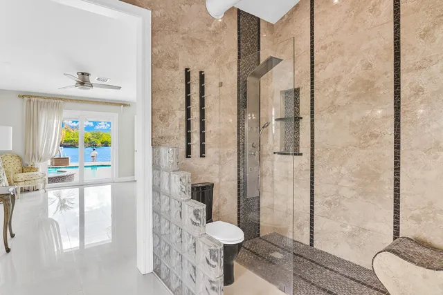 a bathroom with a granite countertop sink a toilet and shower