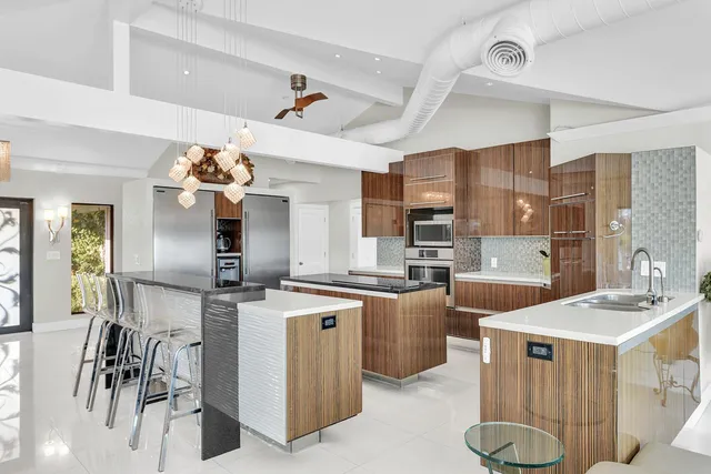 a kitchen with stainless steel appliances granite countertop a sink a stove and a refrigerator