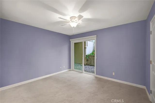 a view of an empty room with chandelier fan