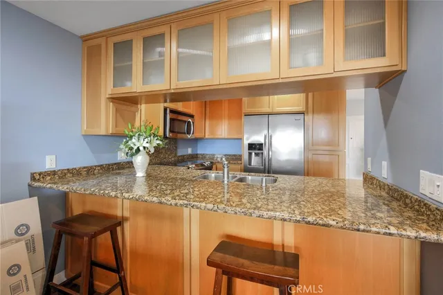 a kitchen with stainless steel appliances granite countertop a sink dishwasher and cabinets with wooden floor