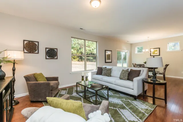 a living room with furniture wooden floor and a window