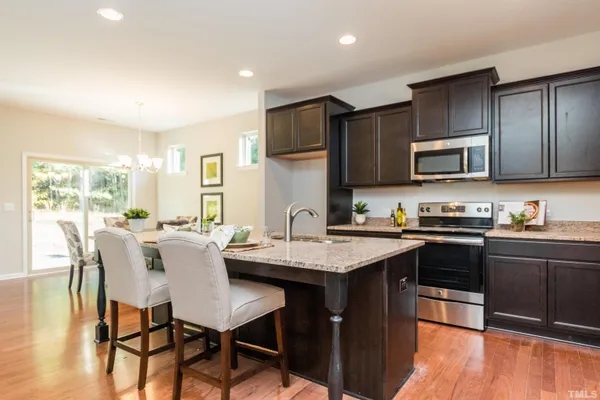 a kitchen with stainless steel appliances granite countertop wooden cabinets a stove top oven a sink and dishwasher