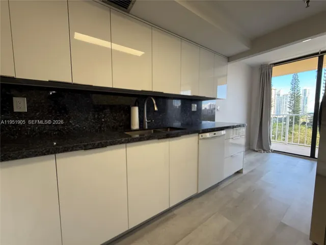 a view of a kitchen with a refrigerator a stove top oven and cabinets