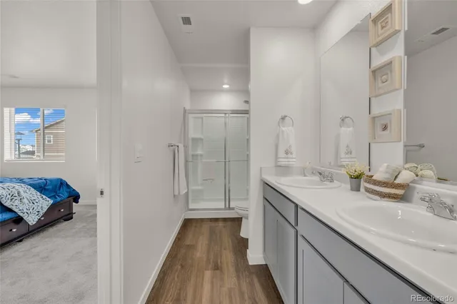 a en suite bathroom with a double vanity sink a mirror and a shower