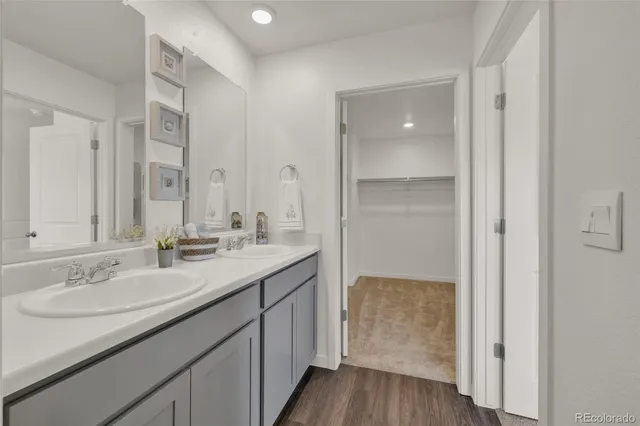 a en suite bathroom with a granite countertop sink and a mirror