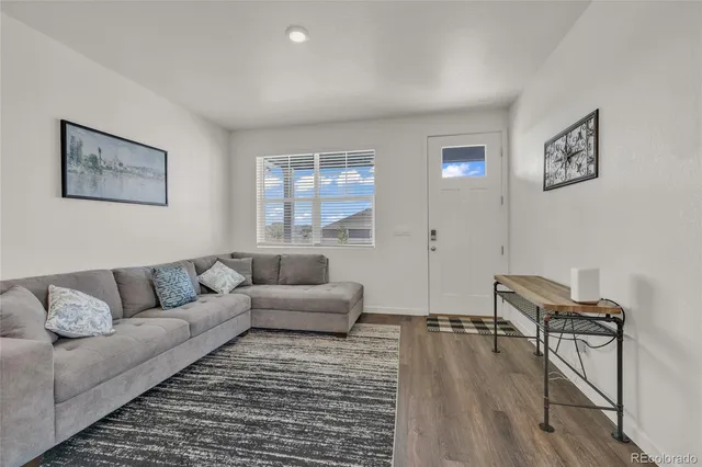a living room with furniture and a wooden floor