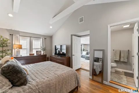 a bedroom with a bed and wooden floor