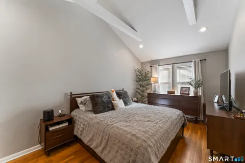 a bedroom with a bed and a flat tv screen on the dresser