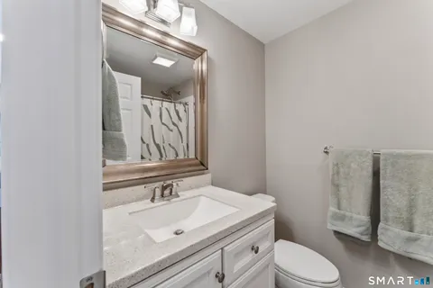 a bathroom with a sink vanity mirror and toilet