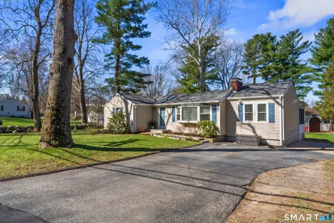 a front view of a house with a yard and trees
