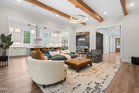 a living room with furniture large windows and wooden floor