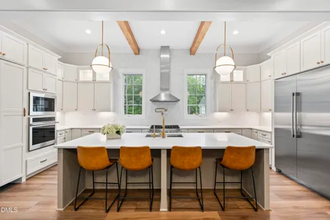 a kitchen with kitchen island a sink appliances cabinets and a large window