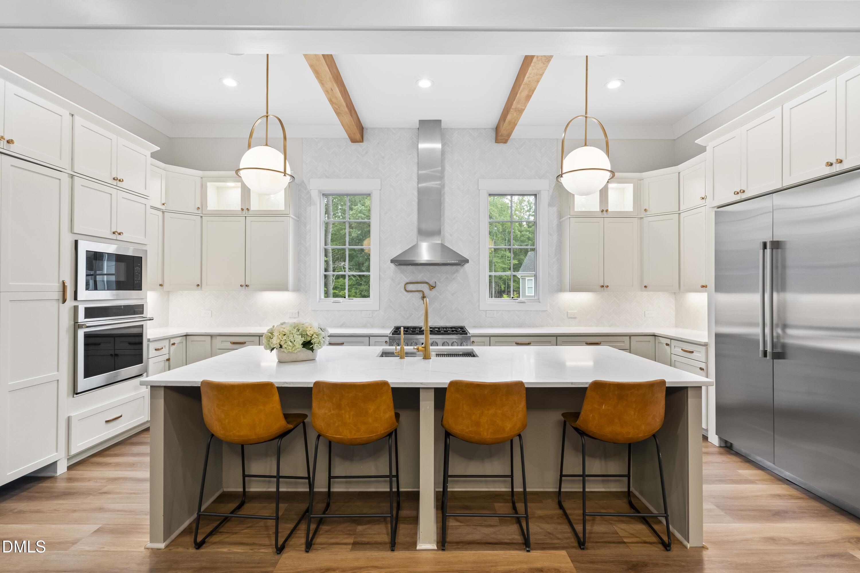 2205 Duskywing Drive Raleigh, NC 27613 - Photo 17 of 38 a kitchen with stainless steel appliances kitchen island granite countertop a table chairs and a refrigerator