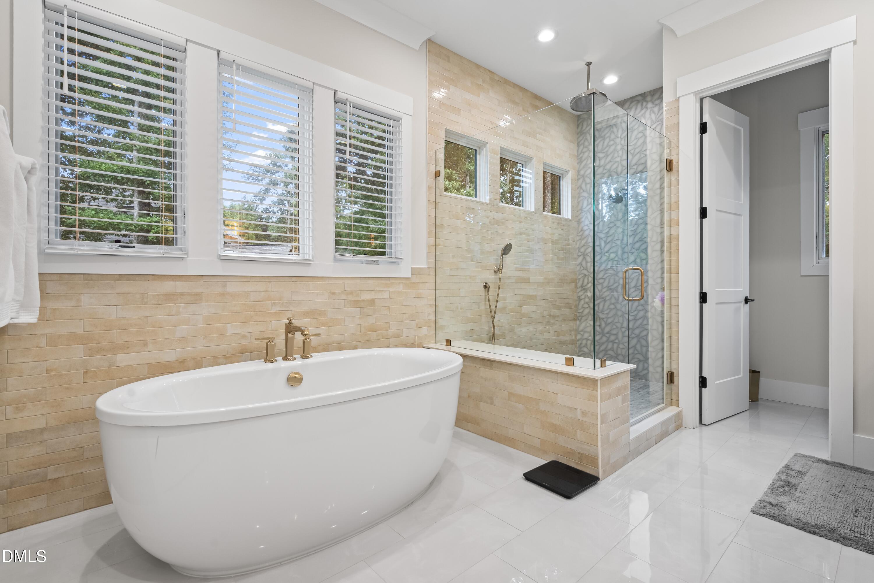 2205 Duskywing Drive Raleigh, NC 27613 - Photo 23 of 38 a bathroom with a white tub sitting next to a window