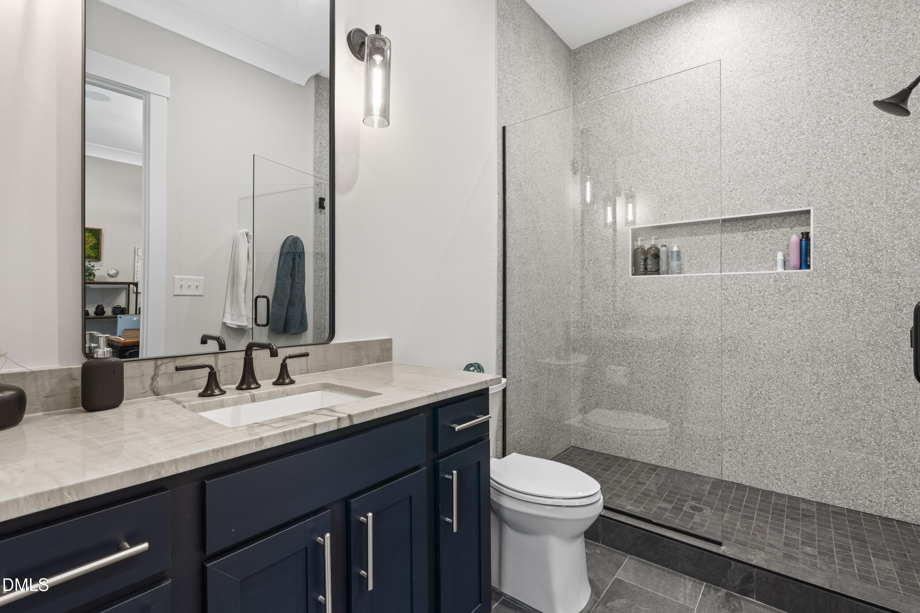 2205 Duskywing Drive Raleigh, NC 27613 - Photo 7 of 38 a bathroom with a granite countertop sink toilet and shower