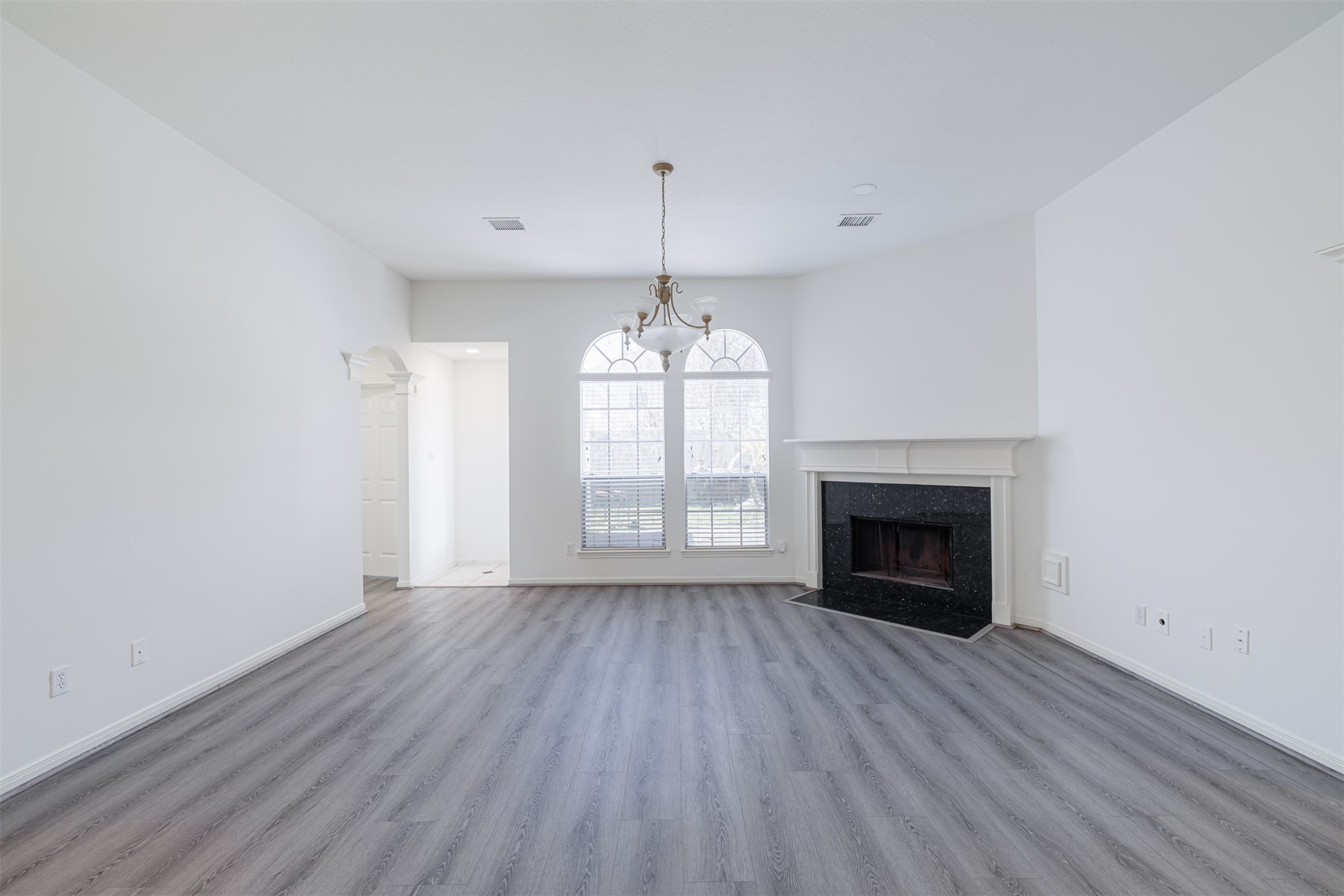 15022 Sapling Oak Court Houston, TX 77082 - Photo 15 of 32 an empty room with wooden floor fireplace and windows