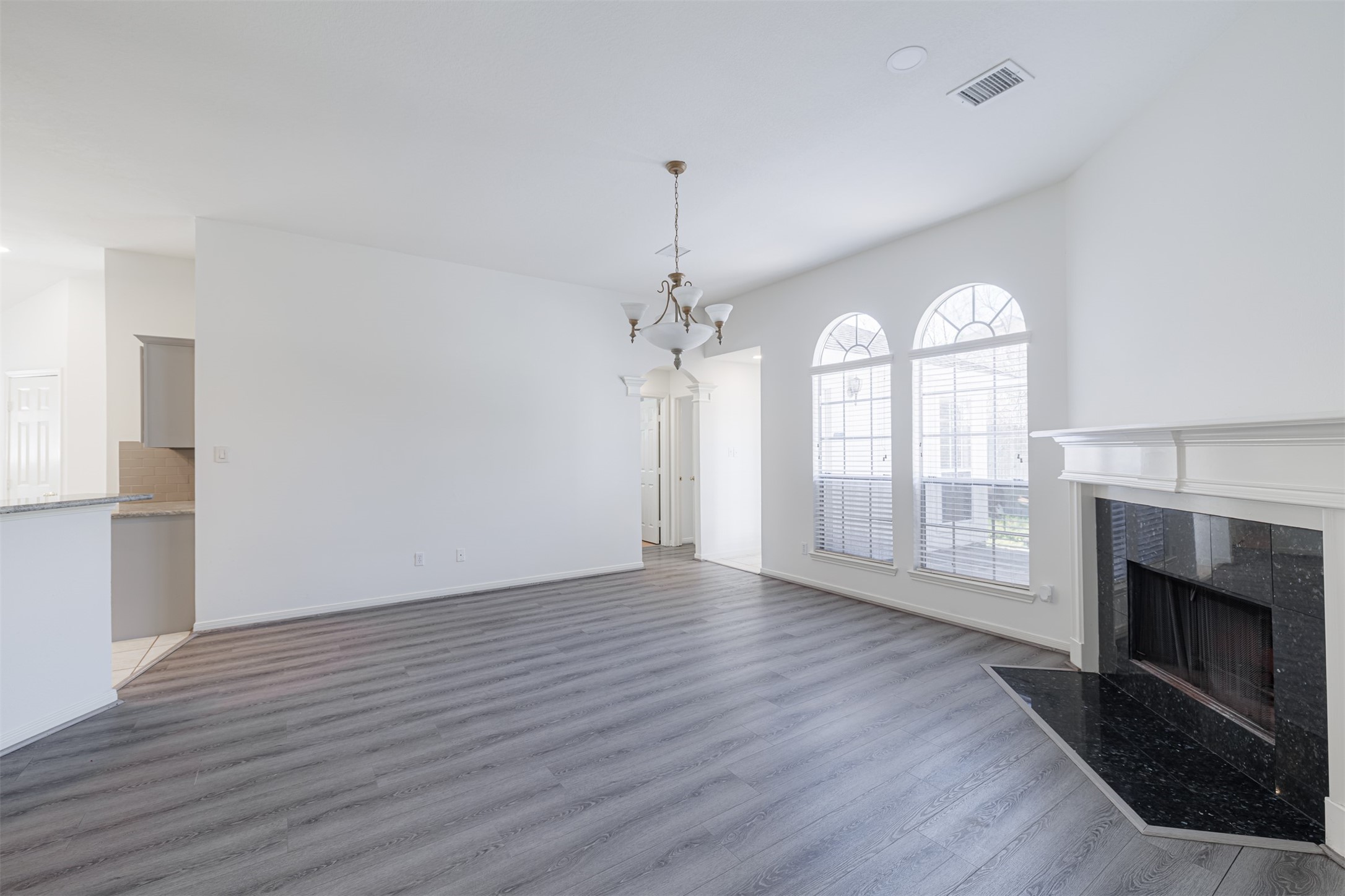 15022 Sapling Oak Court Houston, TX 77082 - Photo 16 of 32 an empty room with wooden floor fireplace and windows