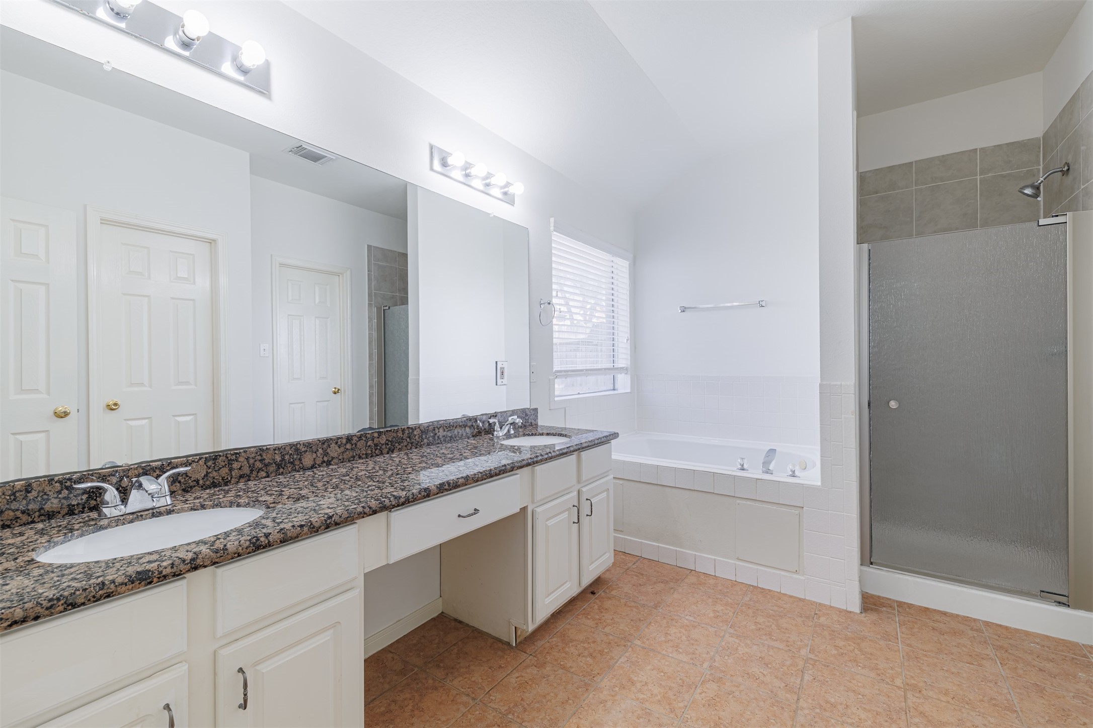 15022 Sapling Oak Court Houston, TX 77082 - Photo 21 of 32 a bathroom with a granite countertop double vanity sink a mirror and a bathtub