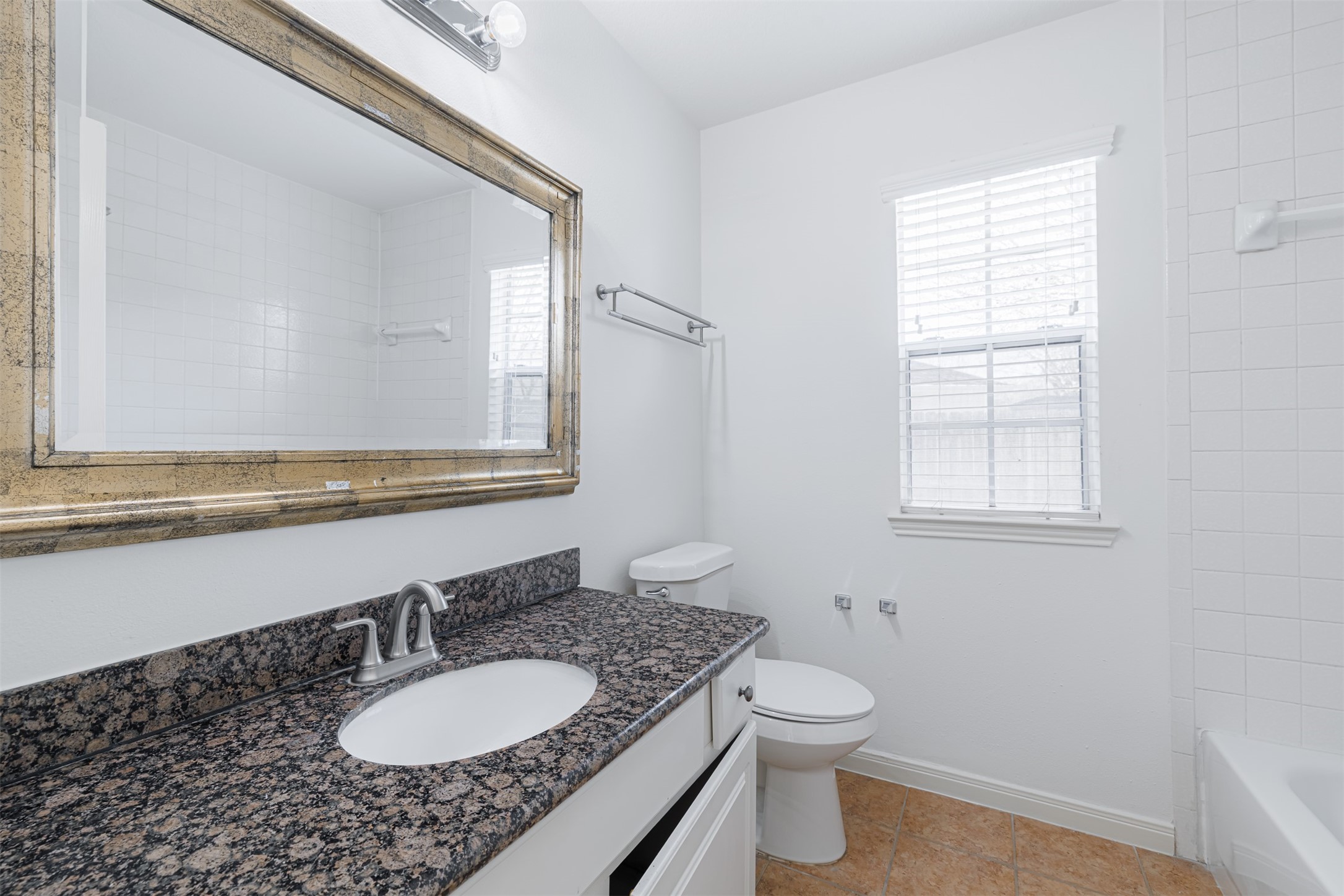15022 Sapling Oak Court Houston, TX 77082 - Photo 26 of 32 a bathroom with a granite countertop sink toilet a mirror and a window