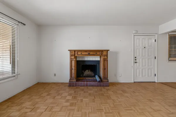 a view of an empty room with a fireplace and window