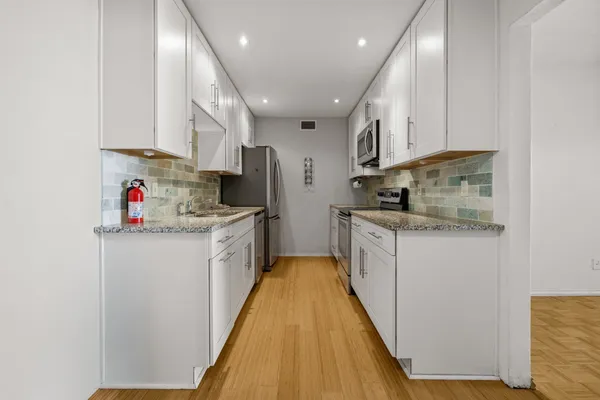 a kitchen with stainless steel appliances granite countertop a sink and cabinets