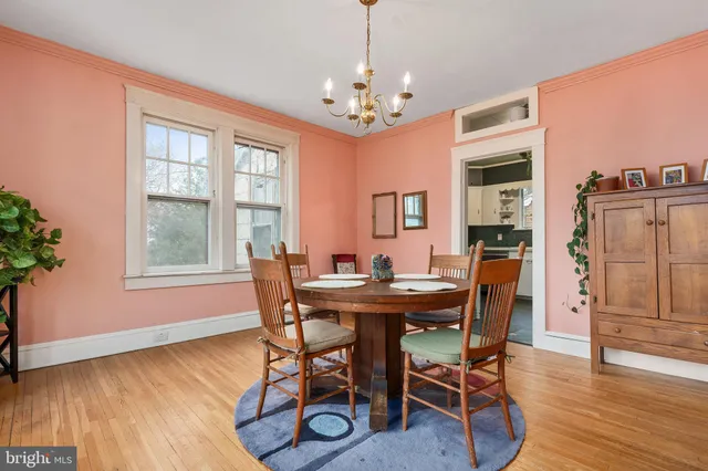 a view of a dining room with furniture a chandelier and wooden floor
