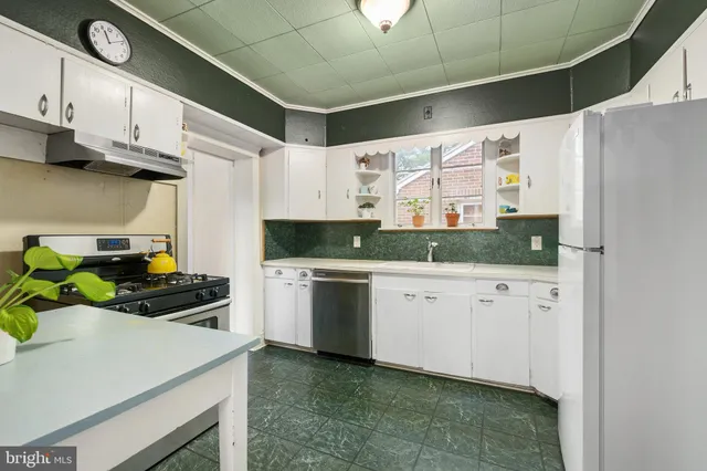 a kitchen with granite countertop white cabinets and white appliances
