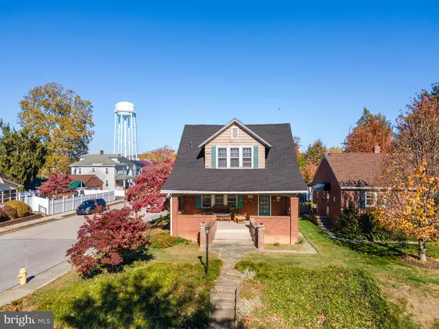 a front view of a house with a yard and fountain