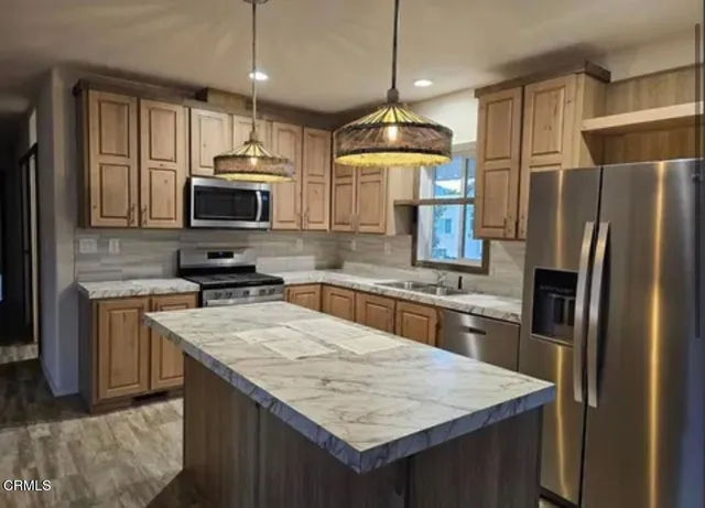 a kitchen with stainless steel appliances granite countertop a sink refrigerator and microwave