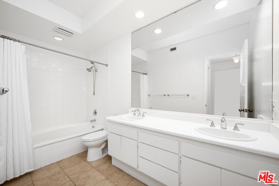 1808 Manning Avenue, Unit 103 Los Angeles, CA 90025 - Photo 9 of 13 a bathroom with a double vanity sink toilet mirror and shower