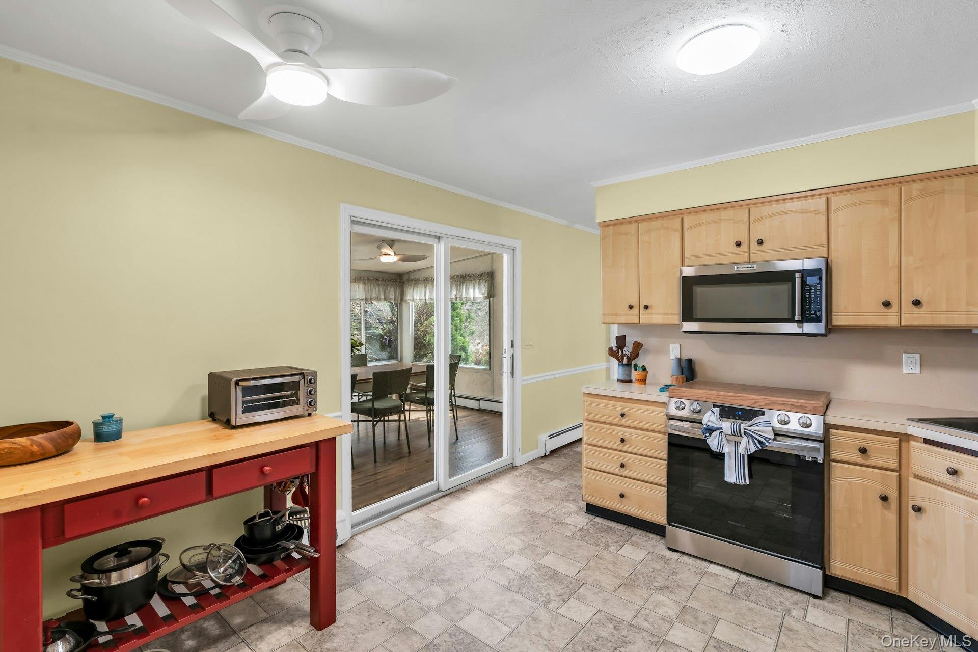 5845 North Bayview Road Southold, NY 11971 - Photo 14 of 26 Kitchen with stainless steel appliances and sliding glass doors that open up to expansive 4 season sun room