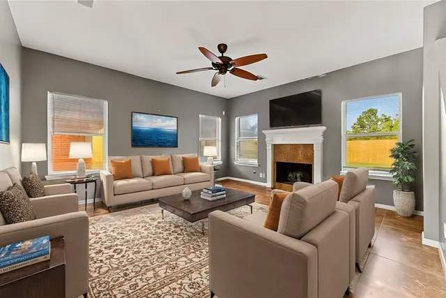 a living room with furniture a fireplace and a flat screen tv