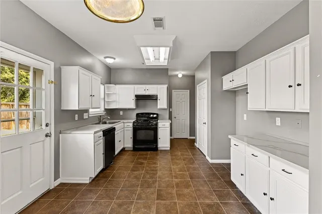 a large kitchen with stainless steel appliances granite countertop a stove a sink and a refrigerator