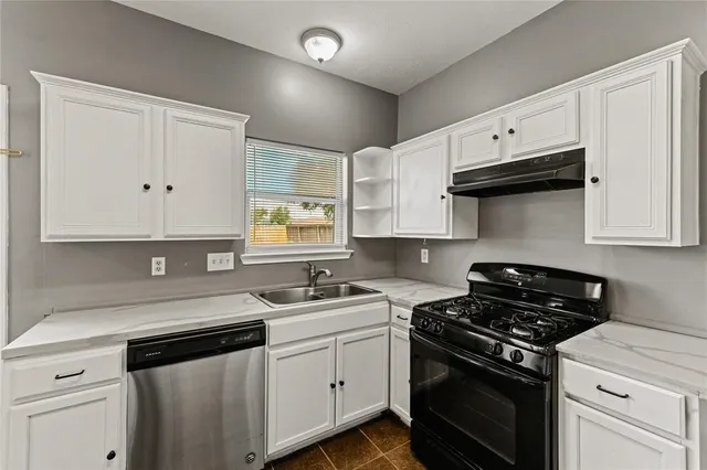 a kitchen with cabinets appliances a sink and a counter top