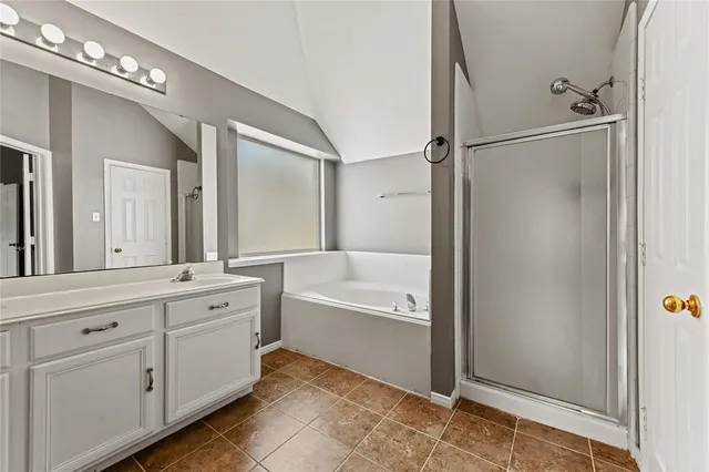 a bathroom with a tub sink shower and mirror