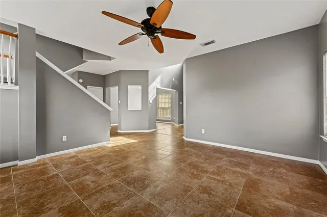 a view of an empty room with a ceiling fan