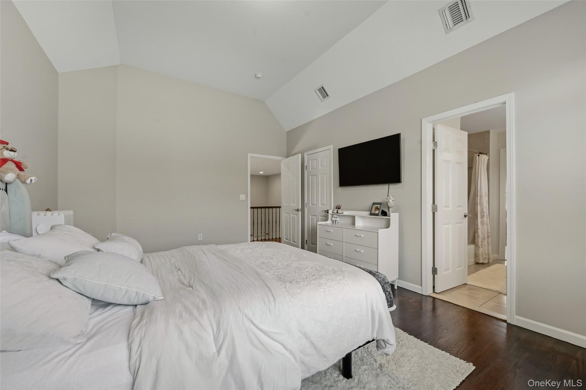 51 Meriwether Trail Congers, NY 10920 - Photo 28 of 50 Vaulted ceiling bedroom with dark wood-finish flooring, light wall paint, and a white six-panel door