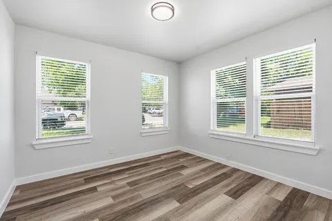 a view of a bedroom with wooden floor and a window