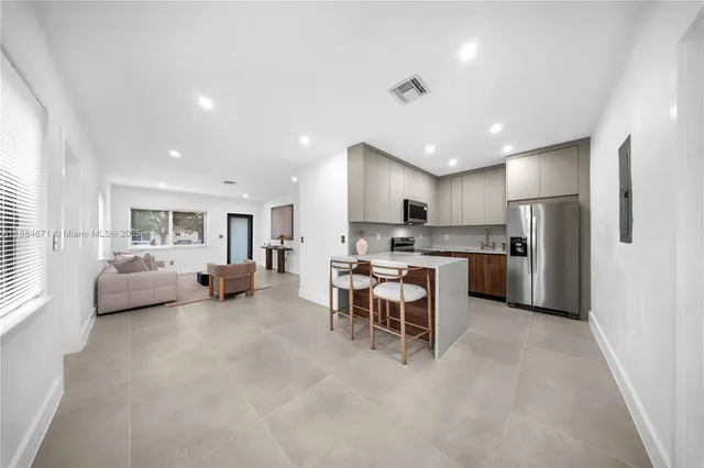 a living room with furniture and kitchen view