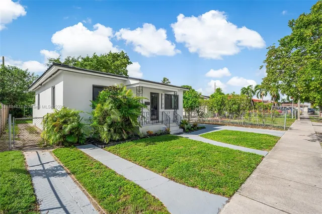 a view of a patio with couches plants and large tree