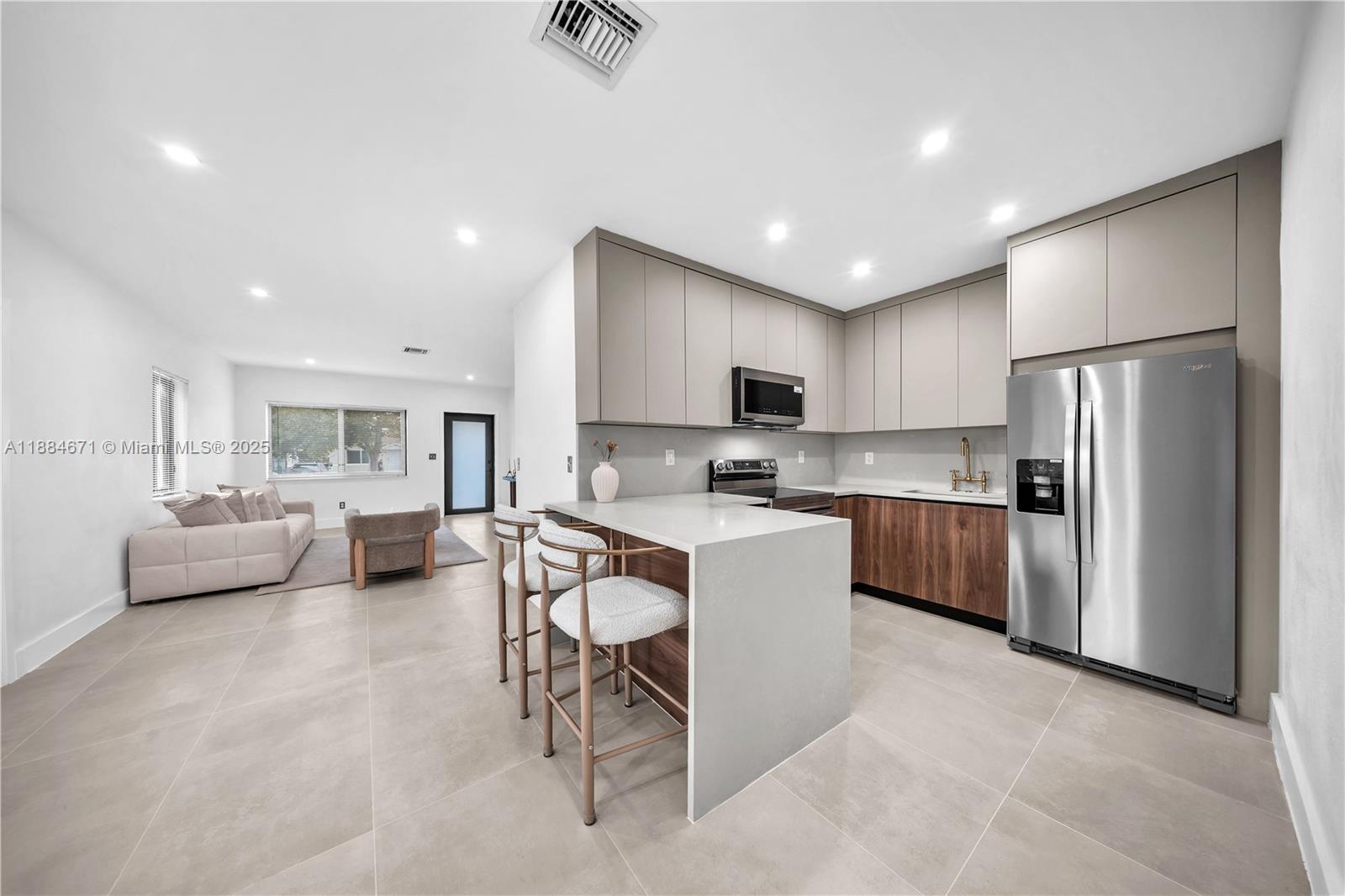 5250 Northwest 4th Street Miami, FL 33126 - Photo 4 of 41 a kitchen with refrigerator a sink and chairs