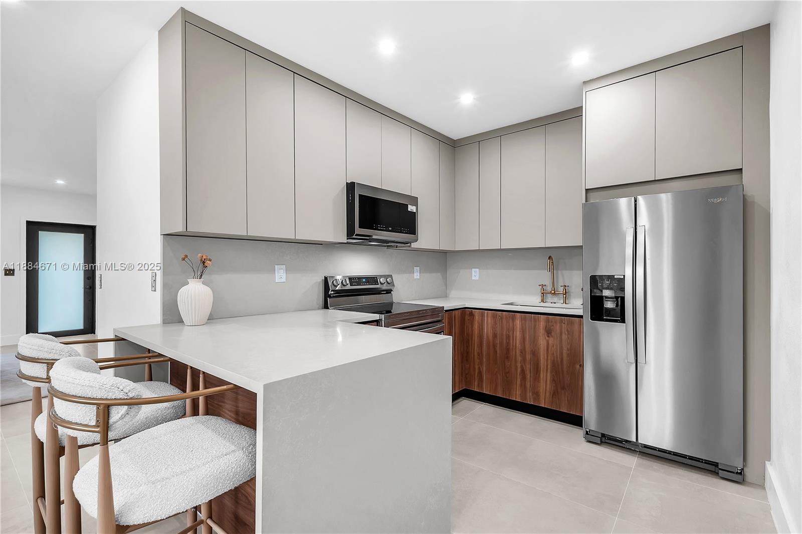 5250 Northwest 4th Street Miami, FL 33126 - Photo 8 of 41 a kitchen with stainless steel appliances granite countertop a refrigerator a stove a sink a dining table and chairs